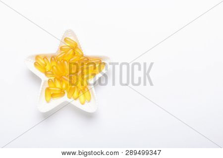 Omega 3 Capsules In Star Shape Plate On White Background Fish Oil Yellow Softgels Vitamin D, E, A Su