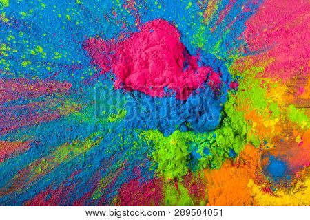 Abstract colorful Happy Holi background. Color vibrant powder on wood. Dust colored splash texture. Flat lay holi paint decoration