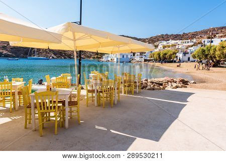 Sifnos, Greece - September 11, 2018 - Tables And Chairs In Traditional Greek Tavern Along Seaside Pr