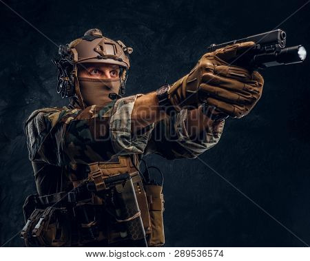 Elite Unit, Special Forces Soldier In Camouflage Uniform Holding A Gun With A Flashlight And Laims A