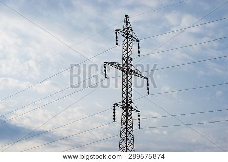 Power Lines Against The Sky With Clouds And Reflections Of Sunlight