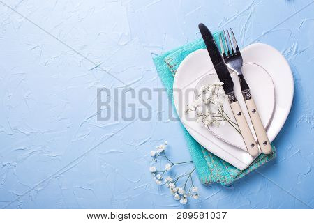 Plates In Form Of Hearts, Napkin, Knife And Fork And  Fresh White Gypsofila  Flowers On Blue Texture