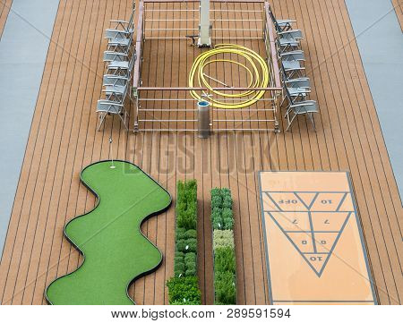 Abstract View Of Games On Board Of A Cruise Ship Miniature Golf, Shuffle Board And Chairs,