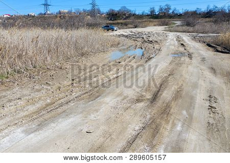 Off-piste. Deep Rubber Tracks On The Road Is Covered With Wet Dirty Sand, Off-road. Traces Of Tires