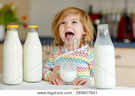 Adorable Toddler Girl Drinking Cow Milk For Breakfast. Cute Baby Daughter With Lots Of Bottles. Heal