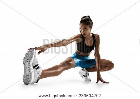 Young African Woman Warming Up Before Run Isolated On White Studio Background. One Female Runner Or 