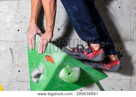 Rocky Shoe On A Tiny, Scanty Snare Stands With The Tip Of The Sock In Close-up On The Climbing Wall 