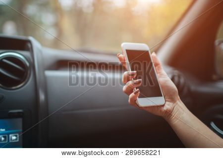 Eautiful Woman Smiling While Sitting On The Front Passenger Seats In The Car. Girl Is Using A Smartp