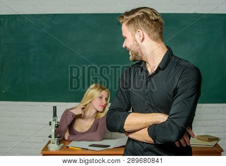 Confident In His Knowledge. Handsome Man Standing Hands Crossed In Classroom With Teacher. Male Stud
