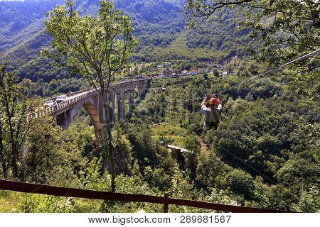 A Man Crosses Over A Long Cable Car Over A Mountain And Forest Across The Tiara River In Montenegro 