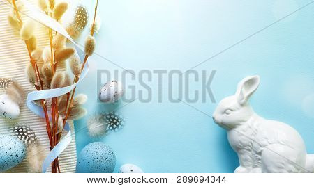 Easter Greeting Card With Colorful Easter Eggs And Sprin Flowersl On Blue Table. Top View With Space