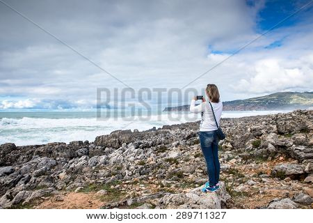 Woman, Girl Takes Pictures On The Beach Of The Atlantic Ocean