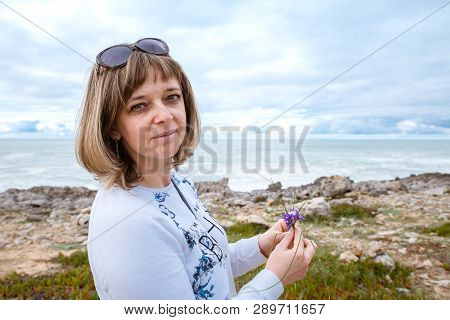 Woman, Girl Collects Flowers On The Shores Of The Atlantic Ocean