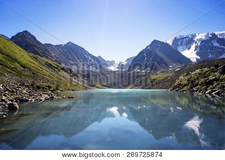 Russia, Altai, Mountains. Beautiful Blue Lake Kucherla In The Foreground Against The Snow-capped Pea