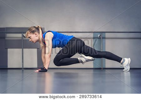 Attractive Young Woman Working Out Indoors. Beautiful Model Doing Exercises In Room With White Walls