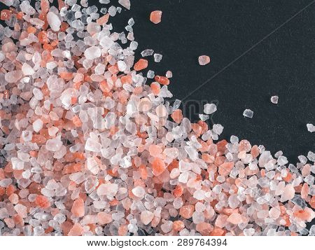 Himalayan Pink Salt In Crystals On Black Stone Background. Copy Space