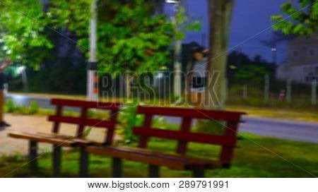 Blurred Image A Young Woman Is Standing By The Road.