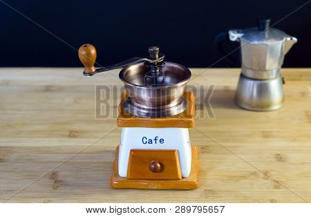 Old Italian Manual Coffee Grinder, Moka Coffee Maker In The Background, Wood Background, Close-up