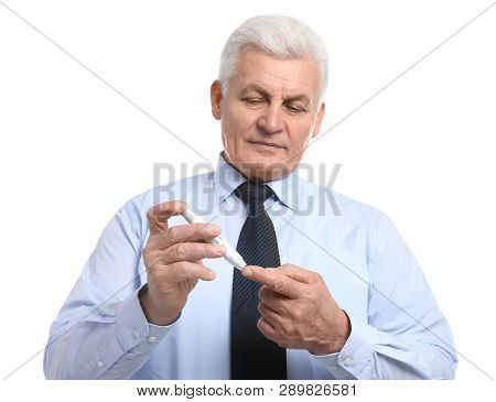 Senior Man Using Lancet Pen On White Background. Diabetes Control