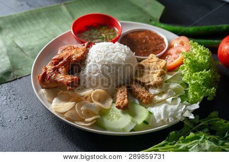 Nasi lemak kukus with fried drumstick, popular traditional Malaysian local food.
