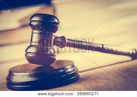 Court hammer in court chambers. Books in the background. Justice, symbol legal system and trial.