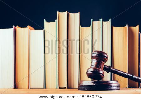Court hammer and books on black background. Court chambers, office of judge. Law and trial.