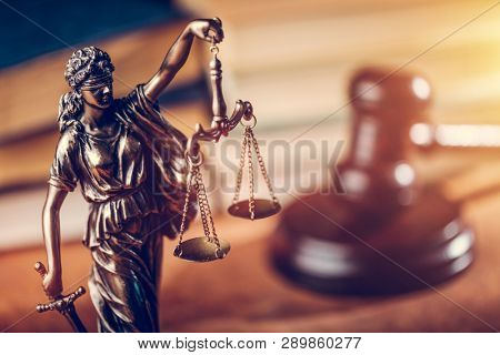 Law and justice concept - Themis statue, judge hammer and books. Courtroom.