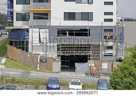Gosford, New South Wales, Australia - March 6, 2019: Workmen Dismantling Scaffolding And Removing Sa