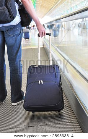 Traveler with a suitcase on the speedwalk