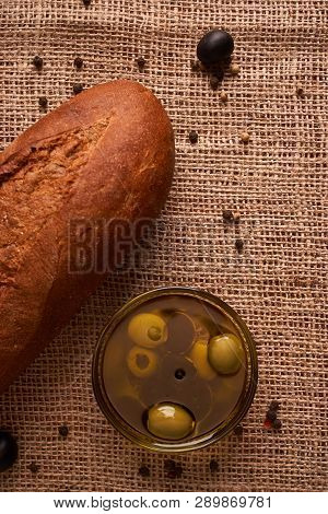 Fresh Bread Baguette With Olive Oil, Olives. Cheese And Rosemary On Wooden Background. Teasty Breakf