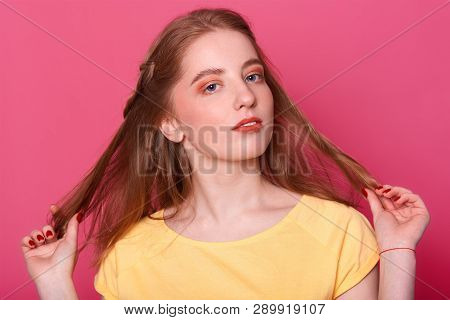 Closeup Portrait Of Beautiful Young Woman Holds Her Straight Long Shiny Brown Hair. Attractive Girl 