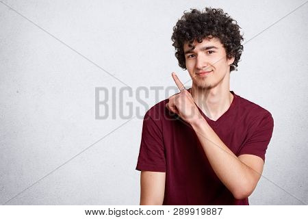 Portrait Of Stylish Handsome Young Teenager Isolated On White Background. Dark Haired Curly Student 
