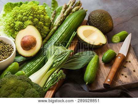Assorted Green Toned Raw Organic Vegetables In Wooden Box On Dark Stone Background. Avocado, Cabbage