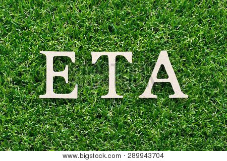 Wood Alphabet In Word Eta (abbreviation Of Estimated Time Of Arrival) On Artificial Green Grass Back