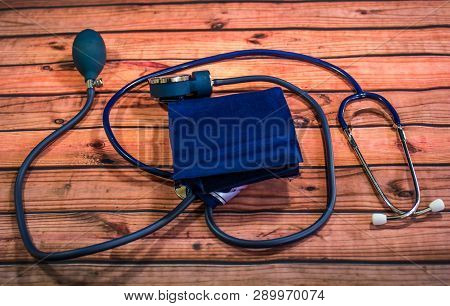 Blood Pressure Cuff, Stethoscope And Release Valve On Wooden Table