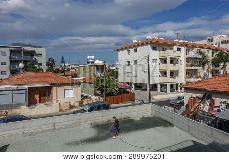 Limassol, Cyprus - November 4, 2018: Man Standing In The Middle Of Recently Levelled Yard  Holding A
