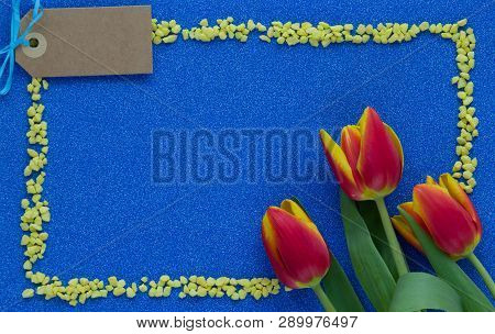 Red And Yellow Tulips On Blue Glitter Background With Copy Space