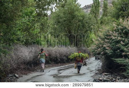 Tibetan People Walking On Rural Road