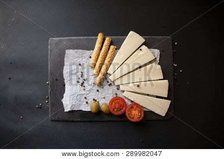 Kasseri Greek Cheese With Tomatoes, Olives And Breadsticks.