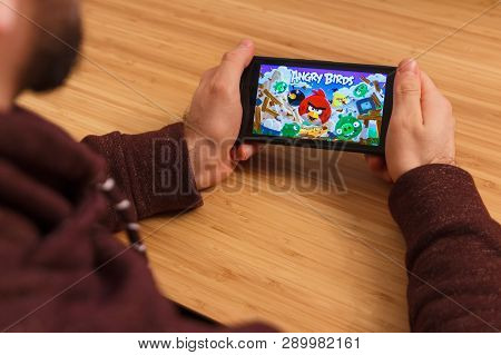 Prague, Czech Republic - March 16, 2019: Man Holding A Smartphone And Playng The Angry Birds Mobile 