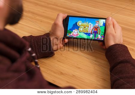 Prague, Czech Republic - March 16, 2019: Man Holding A Smartphone And Playng The Candy Crush Saga Mo