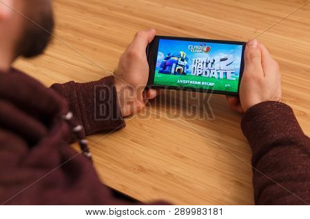 Prague, Czech Republic - March 16, 2019: Man Holding A Smartphone And Playng The Clash Of Clans Mobi