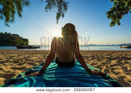 Woman enjoying her holidays on a transat at the tropical beach in Thailand - intentionnal lens flare