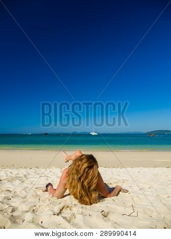 Woman enjoying her holidays on a transat at the tropical beach in Thailand