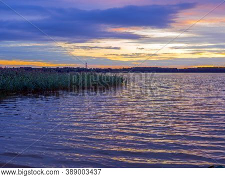 Panoramic View Of Evening Sunset Lake With Green Trees, Mist And Tranquil Reflection. Estonia, Harku