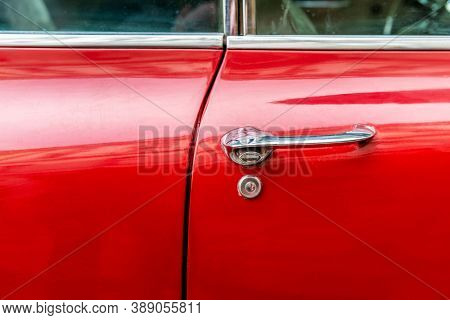 Prage, Czech Republic - Vintage red 60s American car door handle March 9 2019: Red vintage cadillac door