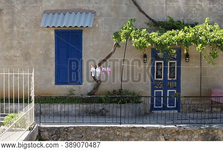 A Scene Of The Front Space Of A Lebanese House With Slippers Left To Dry In The Sun.
