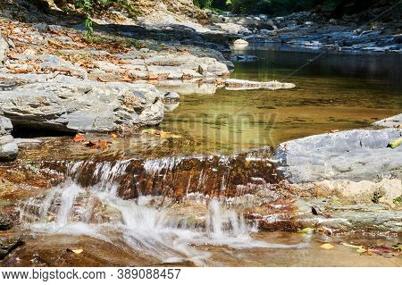 Cascade Of Rapids On A Quiet Mountain River In A Shady Wooded Canyon
