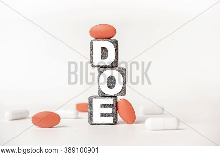 A Group Of White And Red Pills And Cubes With The Word Doe Dyspnea On Exertion On Them, White Backgr