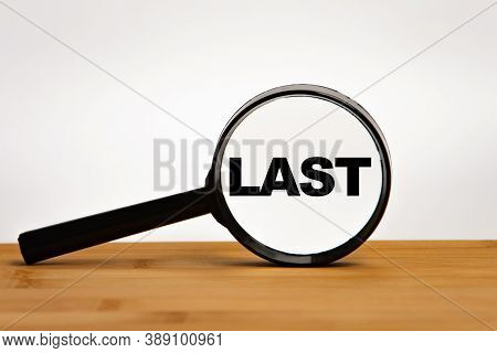 Focused On Business Concept. Magnifier Glass With Word Last On Wooden Table. Business Concept. Searc
